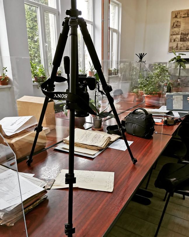 Camera tripod on a desk with historical documents