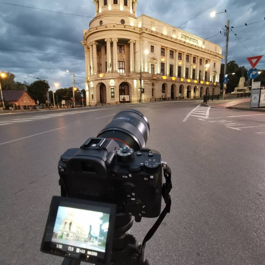 Camera on tripod filming Casa Musicescu at dusk